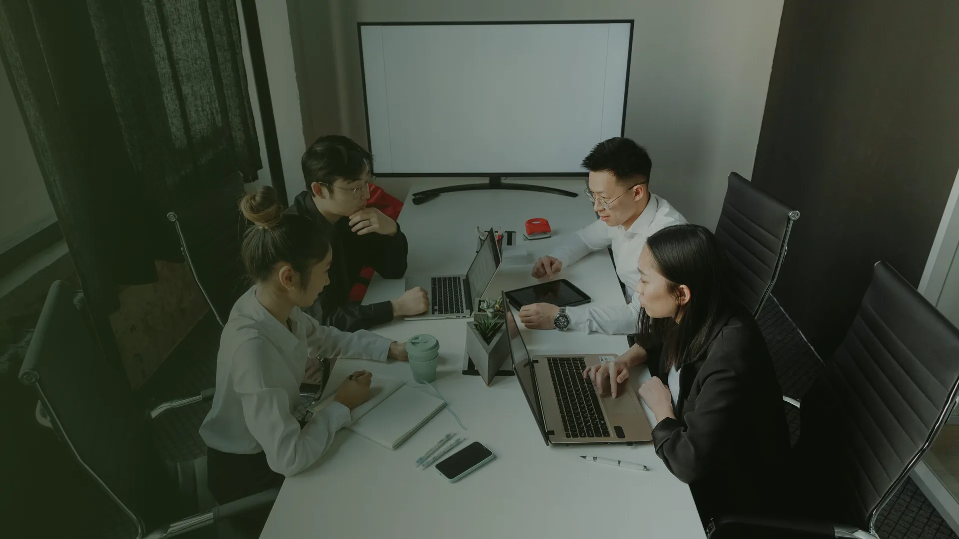 Nhóm làm marketing họp quanh bàn có laptop để lên kế hoạch hệ thống content có AI agent