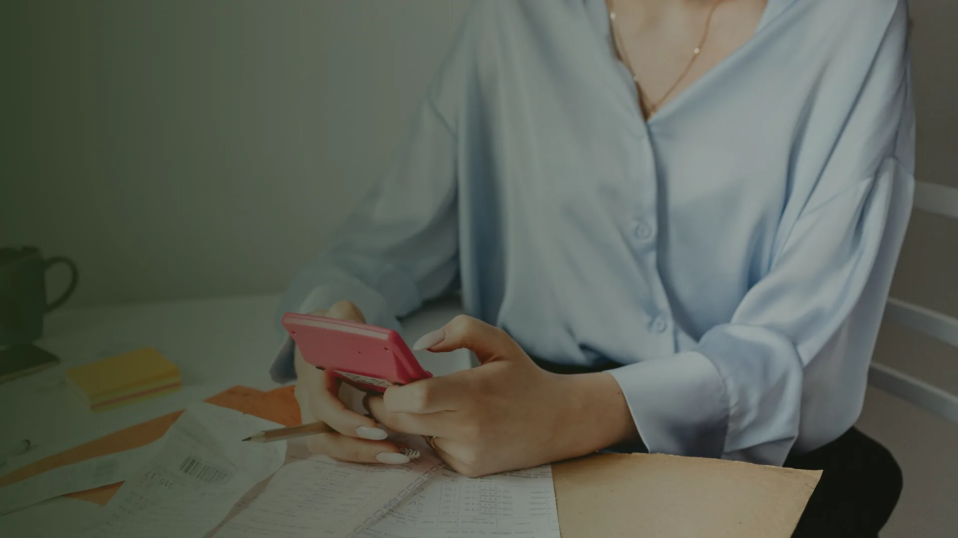 Chủ doanh nghiệp cầm máy tính tính ngân sách marketing bên giấy tờ chi tiêu